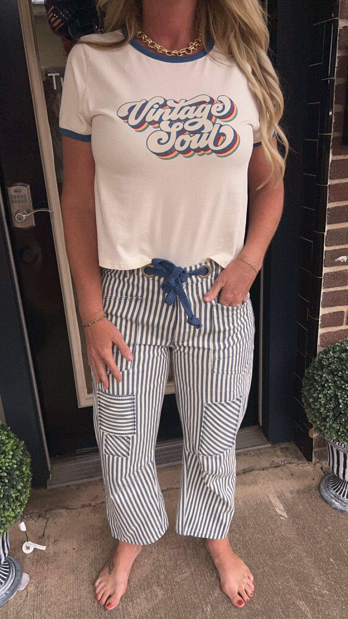 Person wearing a &#39;Vintage Soul&#39; t-shirt and striped pants standing in front of a door.