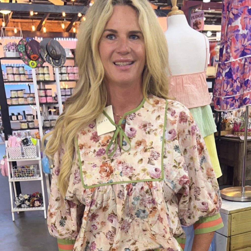 Woman wearing a floral blouse in a store setting