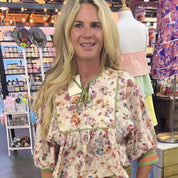 Woman wearing a floral blouse in a store setting